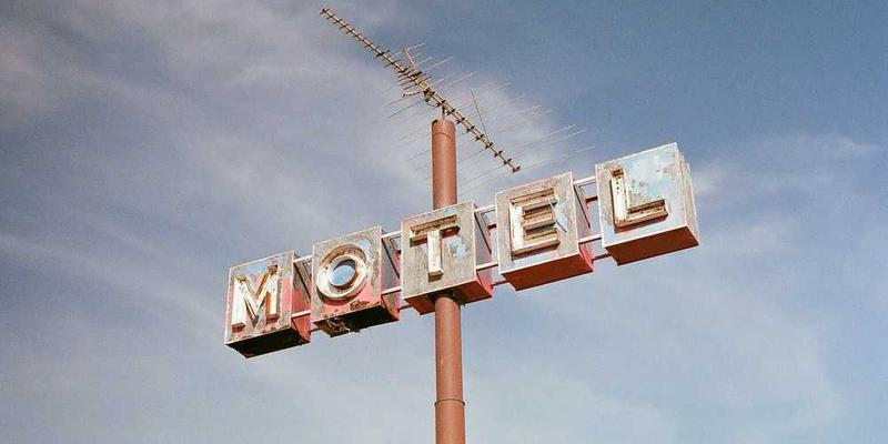 一位穿着运动装的用户对着手机微笑，背景中是一张展示着训练计划与偶像海报的墙